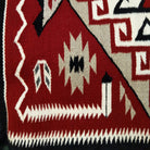 Klagetoh Navajo rug by Adele Mike with a red, black, ivory, and gray geometric pattern framed by a black border.