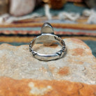 Raymond Coriz sterling silver ring featuring an elongated oval green malachite cabochon with natural dark banding and a textured knurled silver band; underside view.