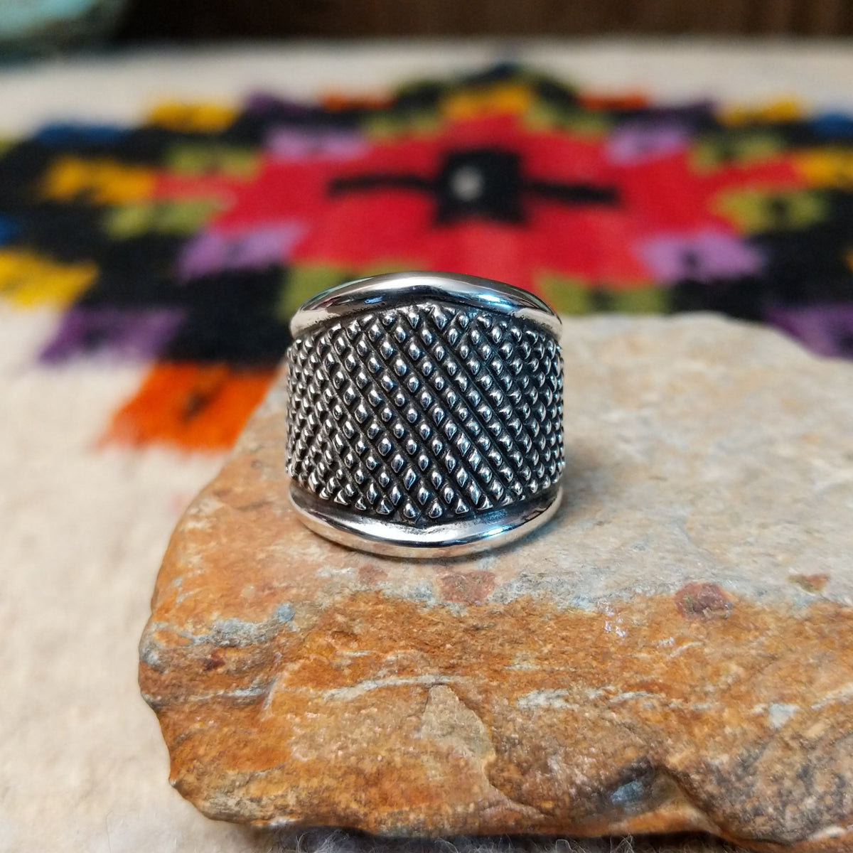 This distinctive Silver Ring by Raymond Coriz features a wide silver band with a raised crosshatch pattern, oxidized detailing, and smooth polished borders along the top and bottom.