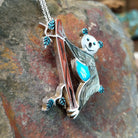 Handcrafted sterling silver koala pin and pendant by Valerie Comozona, featuring detailed inlay and a convertible pin-to-pendant design; side view.
