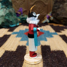 Mini Kokopelli kachina by Rosalind Grey with black-and-white face, white fur collar, feathered crest, and red body.