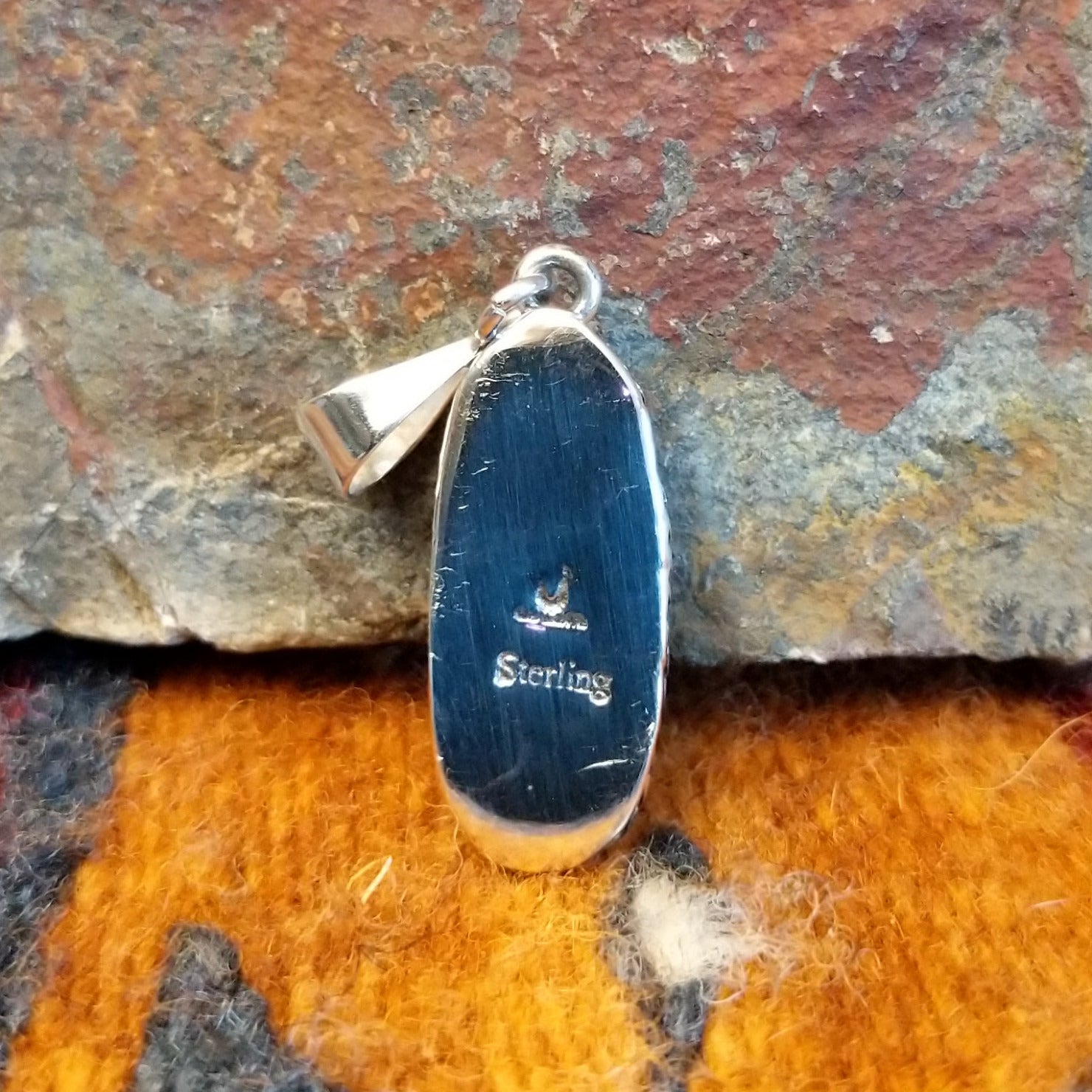 The back features the artisan's stamped signature.
