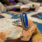 Sterling silver Lapis Lazuli ring by Tim Bedah featuring a capsule-shaped deep blue stone with natural pyrite inclusions; side view.