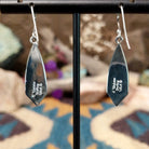 Handcrafted Navajo sterling silver dangle earrings by Cathy Webster featuring deltoid-shaped lapis inlay with polished sterling silver channel accents on French hooks; artisan and Sterling Silver stamp.