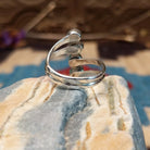 Sterling silver ring with lapis set in four bezels, each suspended on the strands of the band.