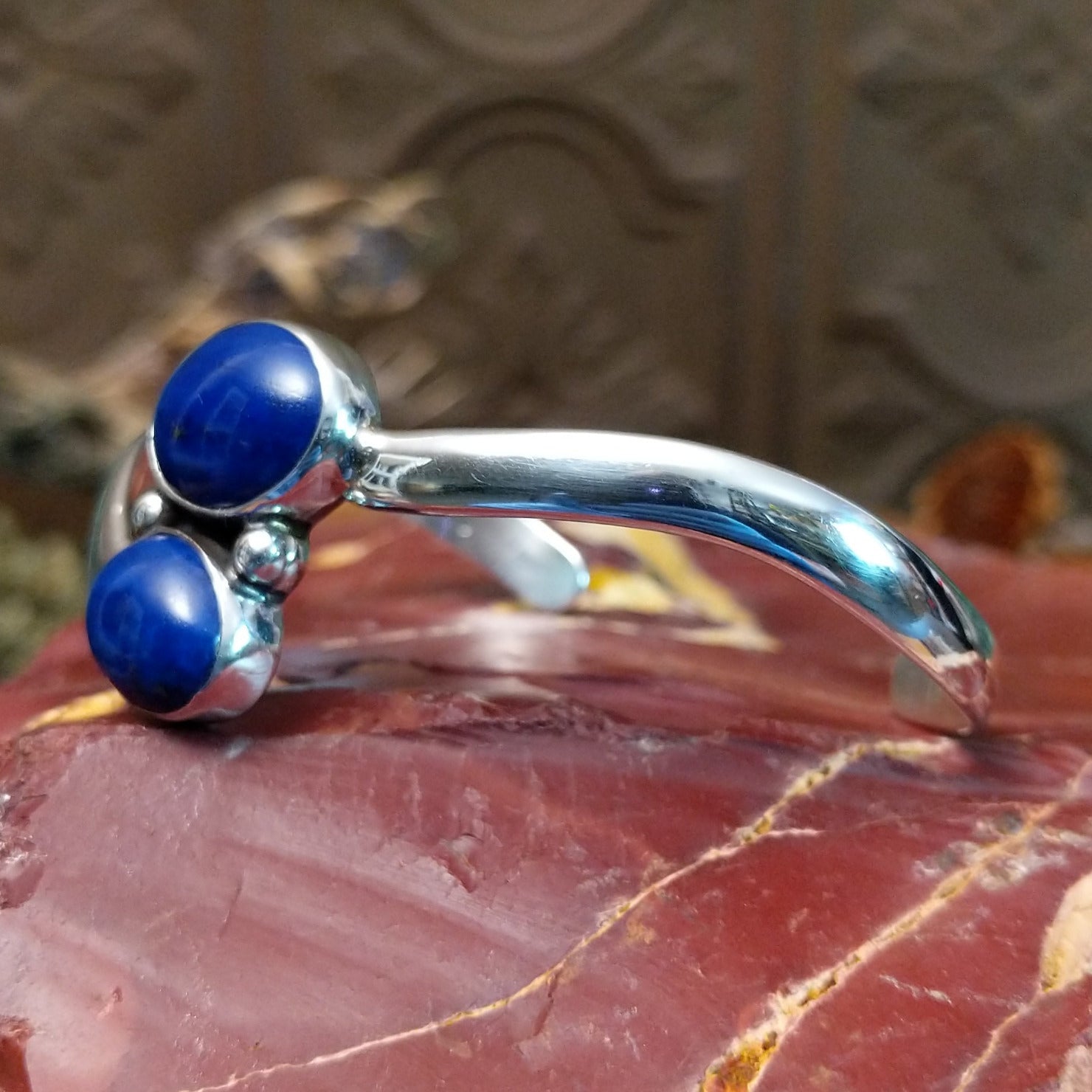 Sterling silver cuff bracelet with lapis set in a duo bezel, framed by dotted accents.