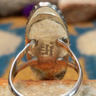 Handcrafted sterling silver ring featuring an elongated marquise-shaped lapis lazuli inlay with diagonal sterling silver geometric accents, framed by a beaded silver border and set on a split sterling silver band; artisan and Sterling Silver stamp.