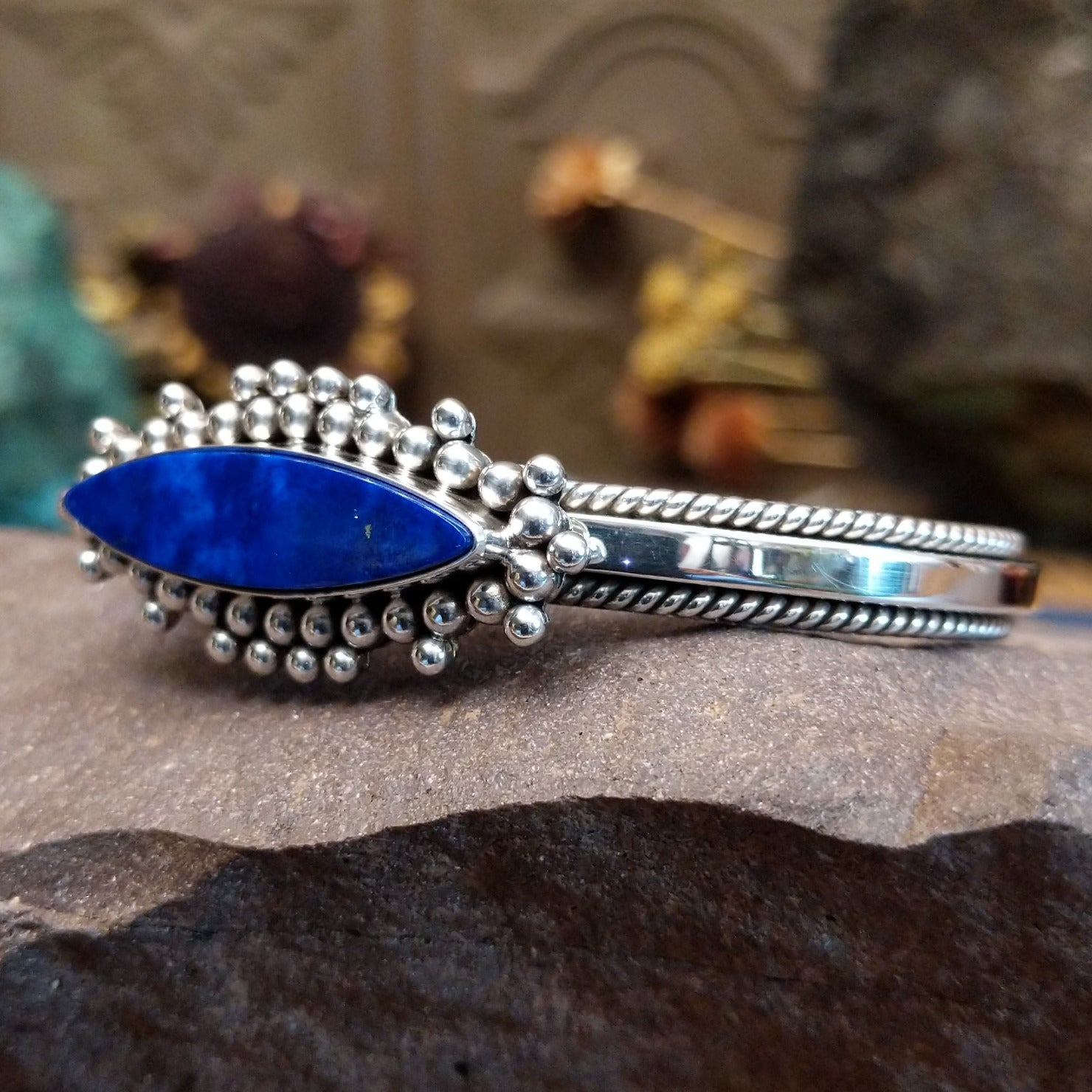 Sterling silver cuff featuring a navette-shaped lapis stone with silver beadwork and twisted rope detailing.