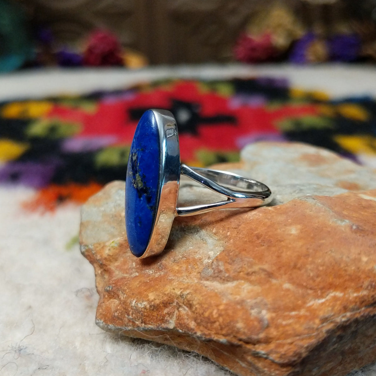 Vibrant Lapis Ring by Cathy Webster featuring an elongated royal-blue lapis stone with natural matrix set vertically in sterling silver with an open split-shank band; side view.