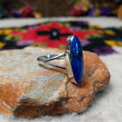 Vibrant Lapis Ring by Cathy Webster featuring an elongated royal-blue lapis stone with natural matrix set vertically in sterling silver with an open split-shank band; side view.