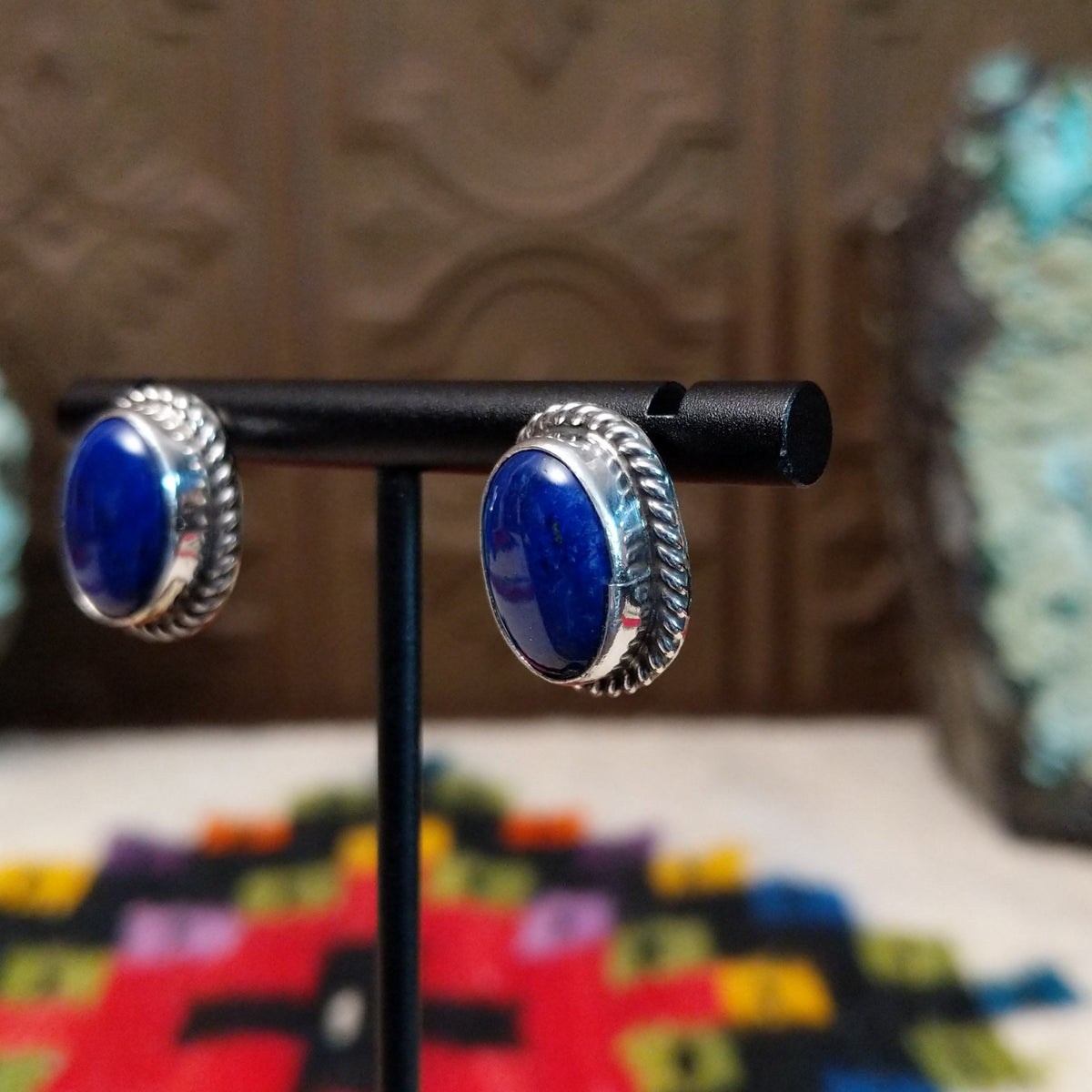 Lapis Oval Earrings by Priscilla Smith featuring deep blue oval lapis cabochons set in polished silver with twisted rope-style borders; side view.