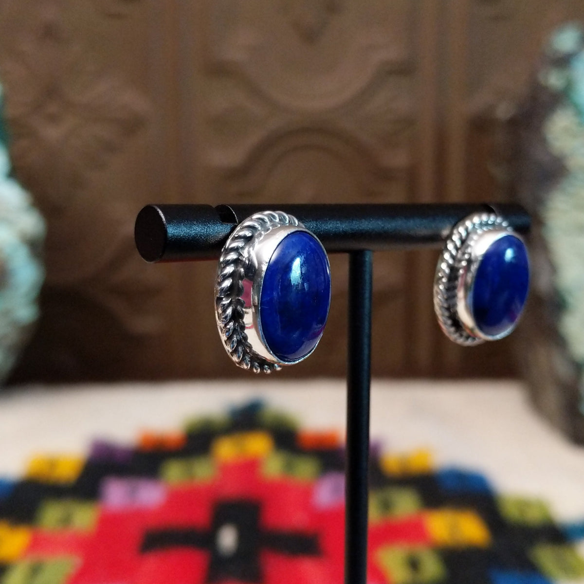 Lapis Oval Earrings by Priscilla Smith featuring deep blue oval lapis cabochons set in polished silver with twisted rope-style borders; side view.