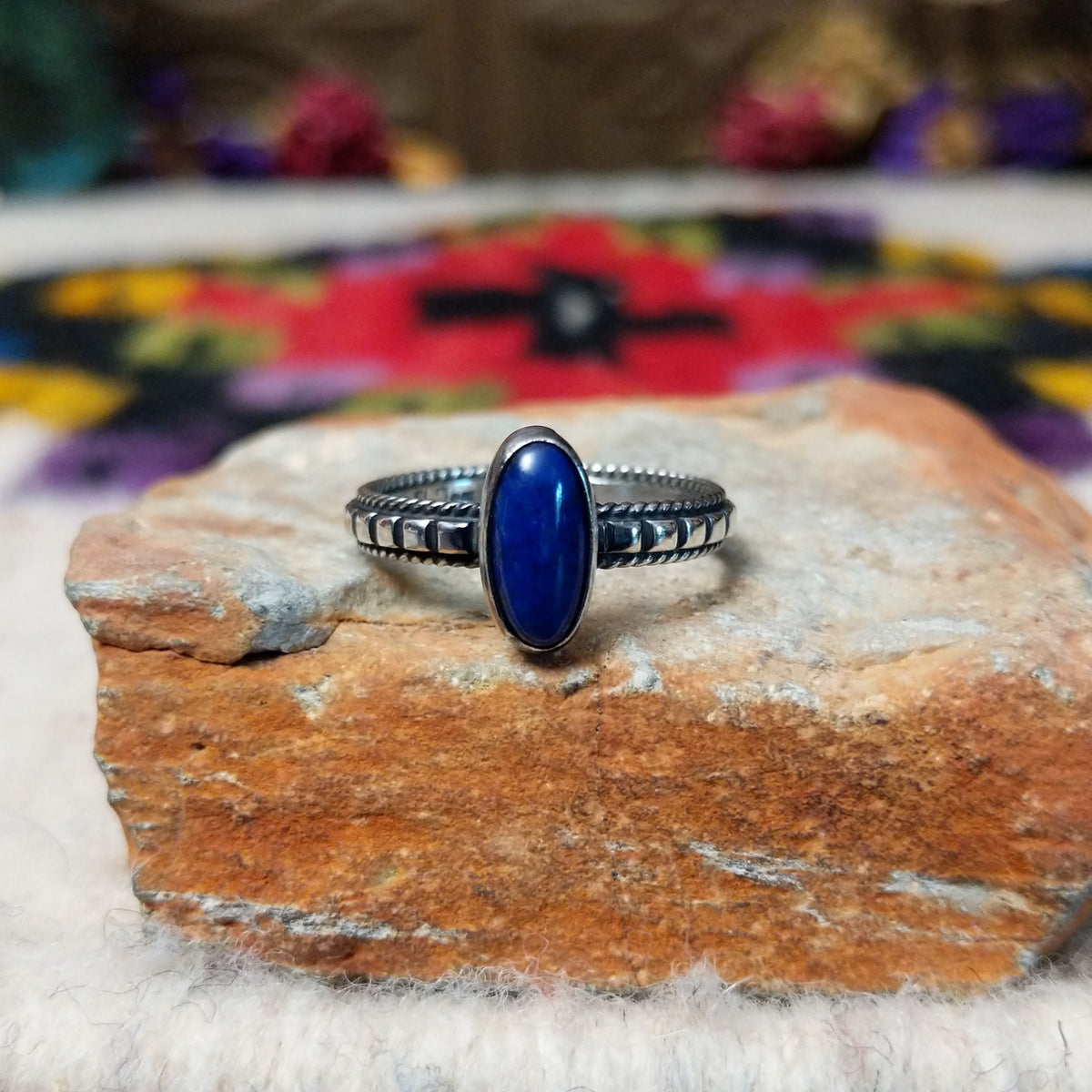 Elegant Lapis Oval Ring by Elgin Tom with an elongated deep blue lapis stone set in sterling silver with twisted-rope edging and oxidized band details.
