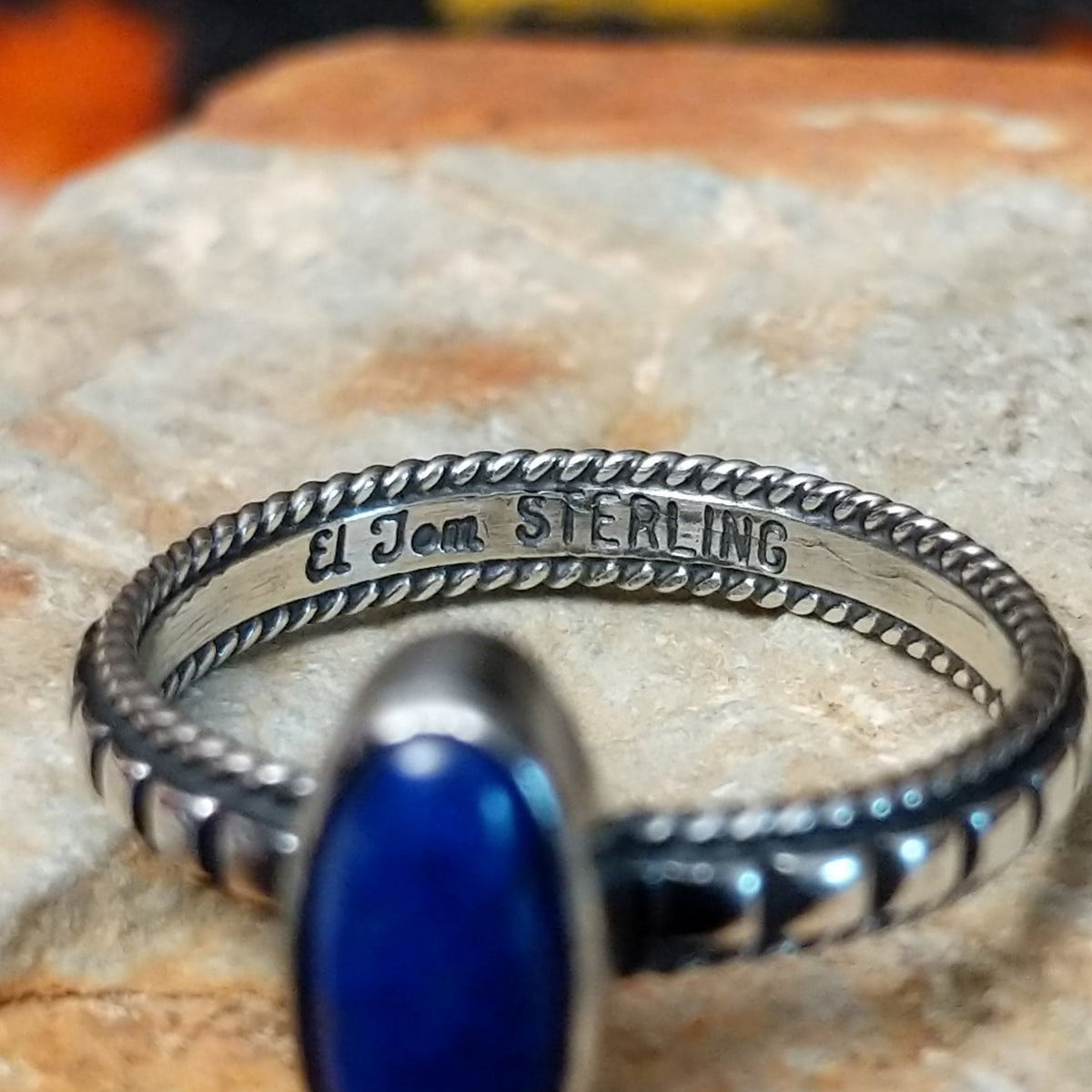 Elegant Lapis Oval Ring by Elgin Tom with an elongated deep blue lapis stone set in sterling silver with twisted-rope edging and oxidized band details; artisan and Sterling Silver stamp.