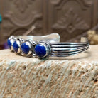 Sterling silver cuff bracelet with lapis set in a quintet of round bezels, framed by twisted rope and dotted accents.