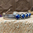 Sterling silver cuff bracelet with lapis set in a quintet of round bezels, framed by twisted rope and dotted accents.