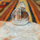 Lapis Ring by J. Chee featuring an elongated oval royal blue lapis lazuli stone set in sterling silver with a twisted rope bezel and decorative scalloped side accents; underside view.