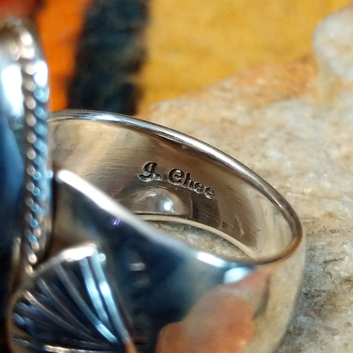 Lapis Ring by J. Chee featuring an elongated oval royal blue lapis lazuli stone set in sterling silver with a twisted rope bezel and decorative scalloped side accents; artisan stamp.