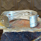 Sterling silver cuff bracelet with layered strands and lapis set in bezels across the surface.