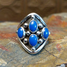 Sterling silver ring with lapis set in tetrad bezels along the surface and dotted accents.
