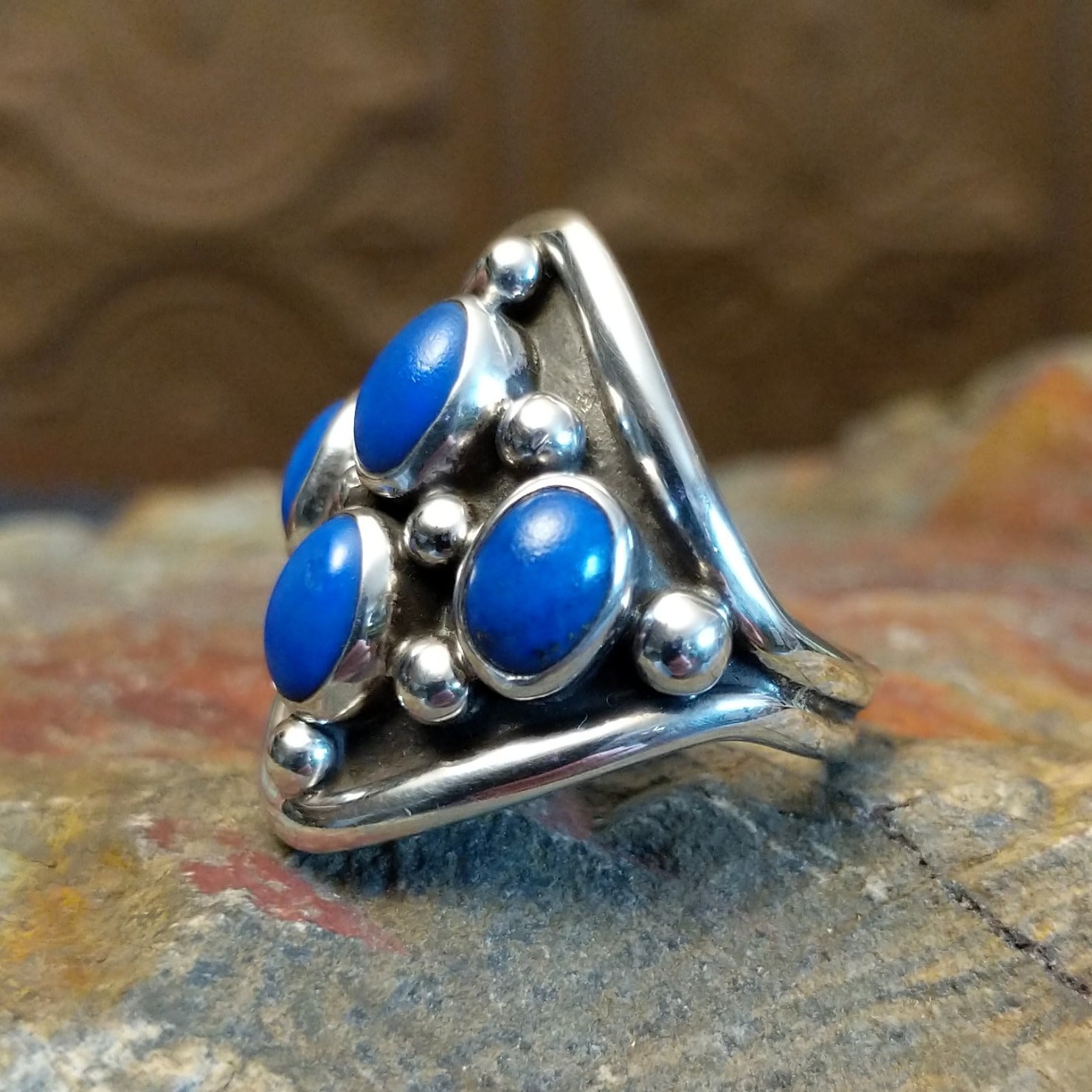 Sterling silver ring with lapis set in tetrad bezels along the surface and dotted accents.