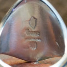 Close-up of the artisan's stamped signature.