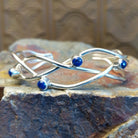 Sterling silver cuff bracelet with interwoven strand band and lapis set in scattered bezels.
