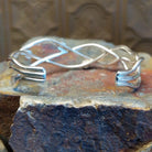 Sterling silver cuff bracelet with interwoven strand band and lapis set in scattered bezels.