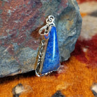 Sterling silver triangular pendant with lapis set in the bezel, framed by incised stamping.