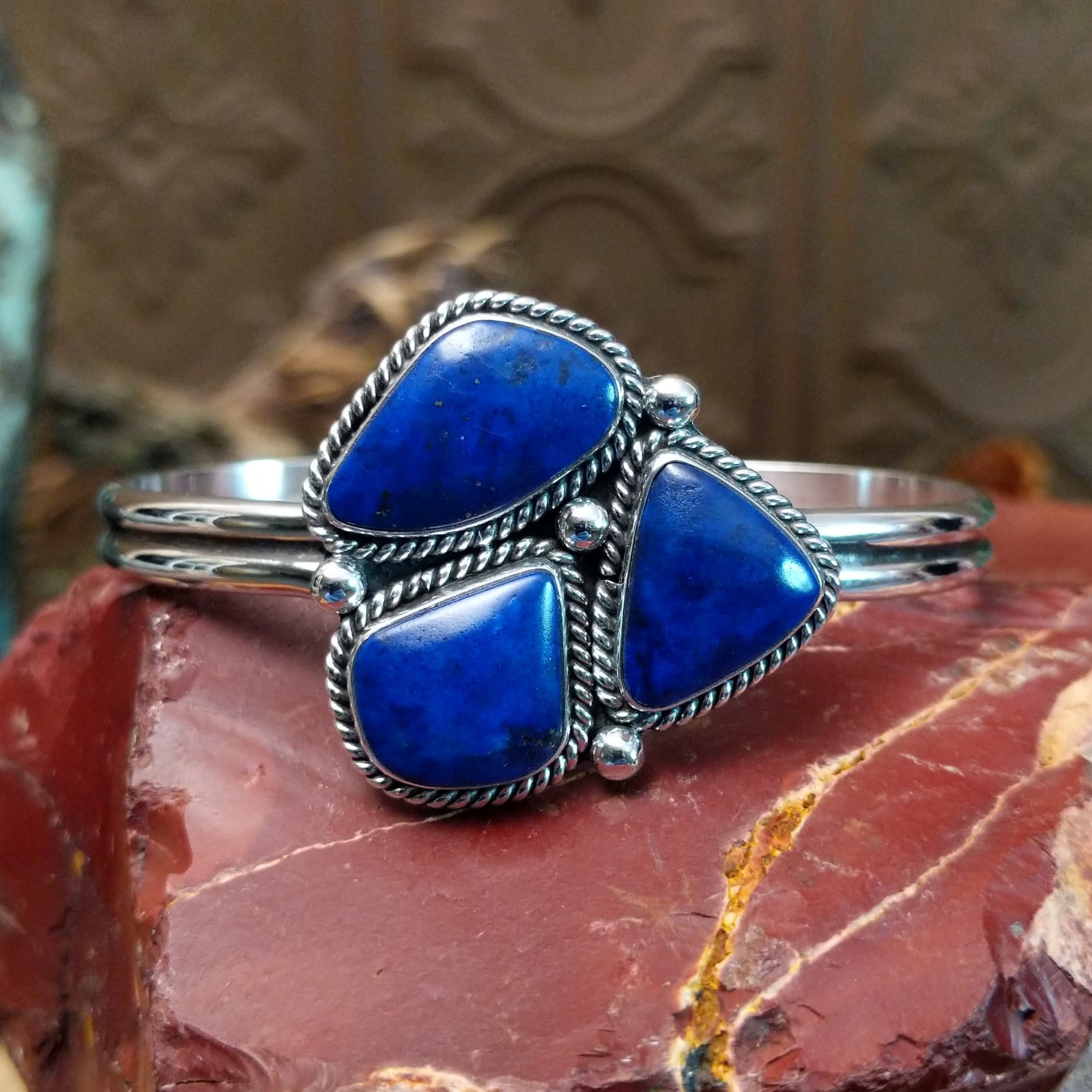 Sterling silver cuff bracelet with lapis set in a triad of bezels, framed by twisted rope accents.