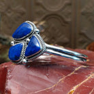 Sterling silver cuff bracelet with lapis set in a triad of bezels, framed by twisted rope accents.