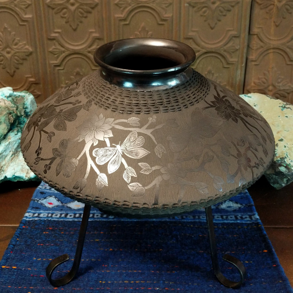 Floral and geometric designs are displayed all along the pot.