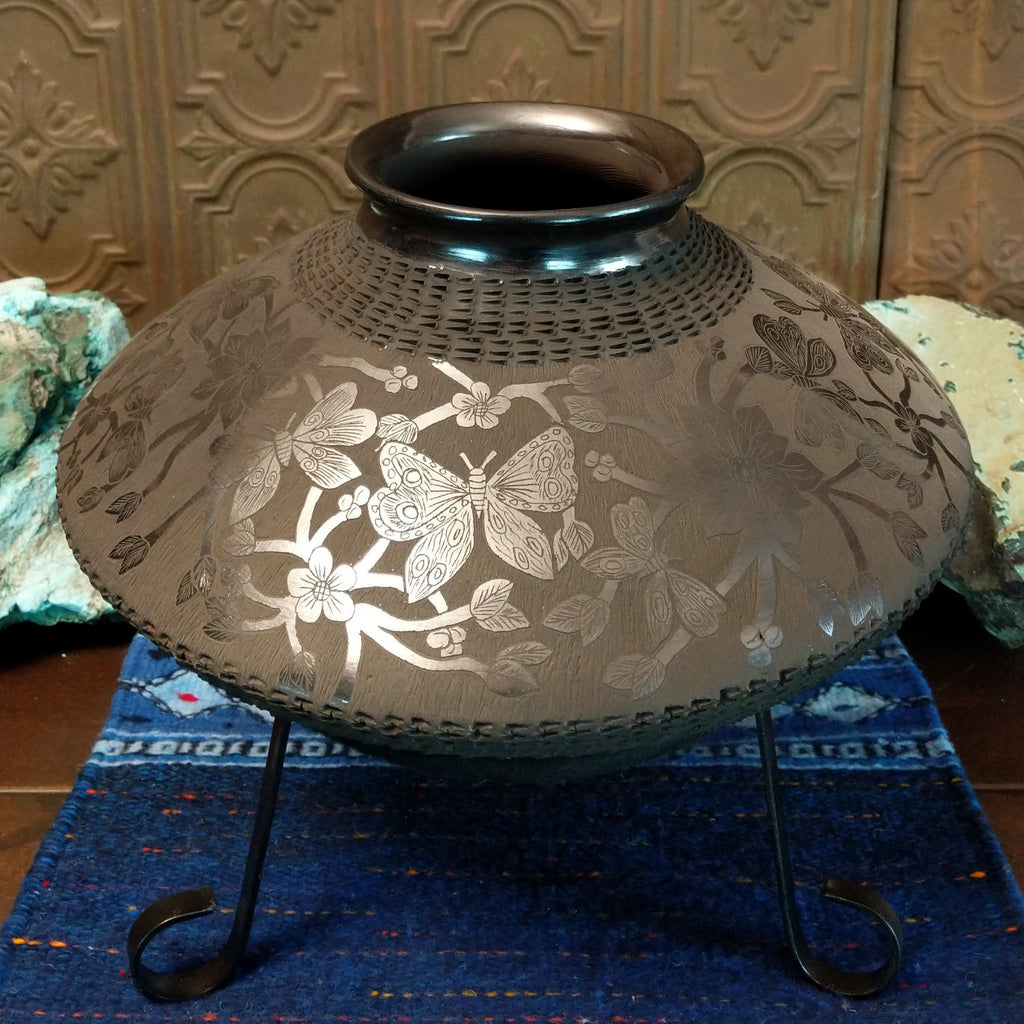 Floral and geometric designs are displayed all along the pot.