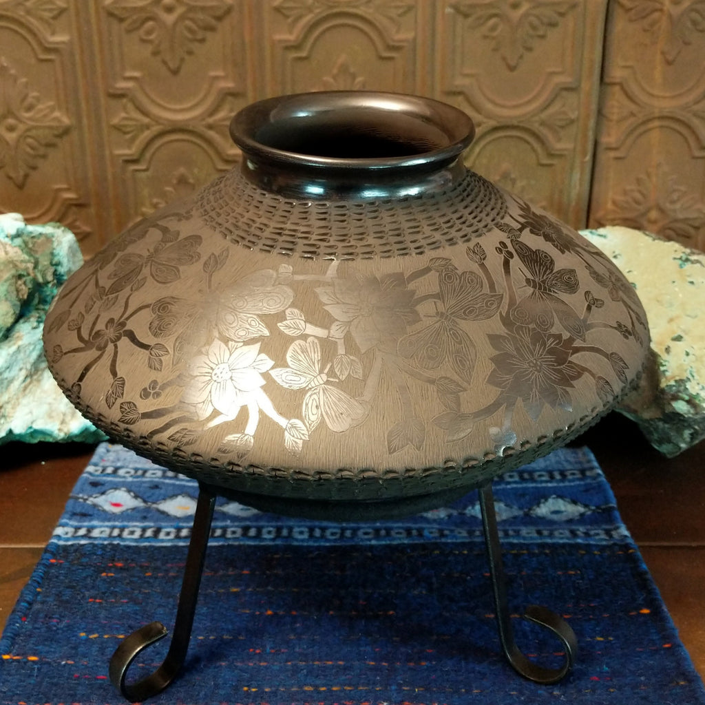 Floral and geometric designs are displayed all along the pot.