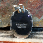 The back of the pendant features the artisan's signature.