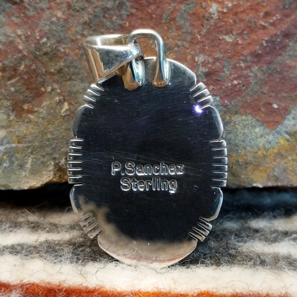 The back of the pendant features the artisan's signature.