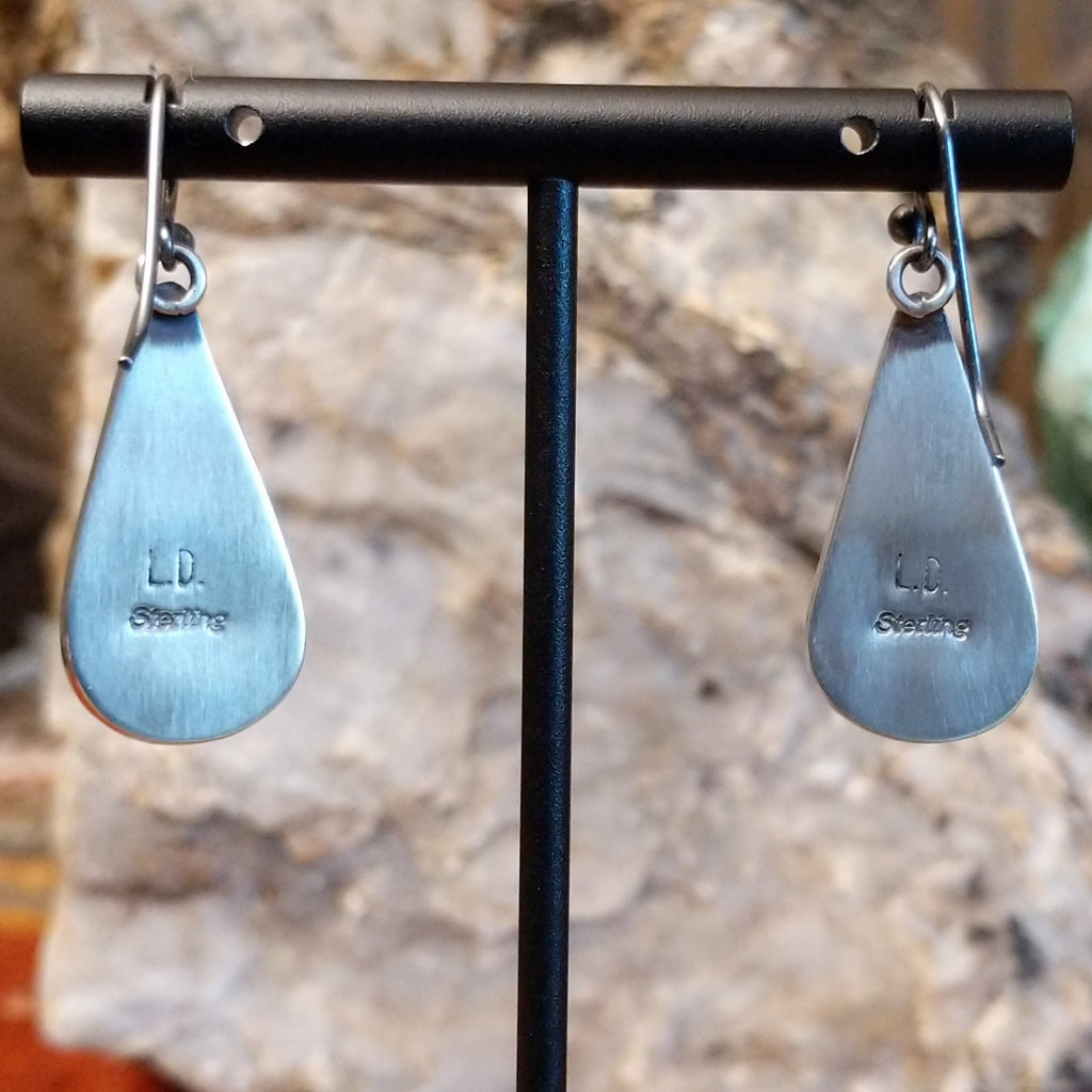 The back features the artisan's stamped initials.