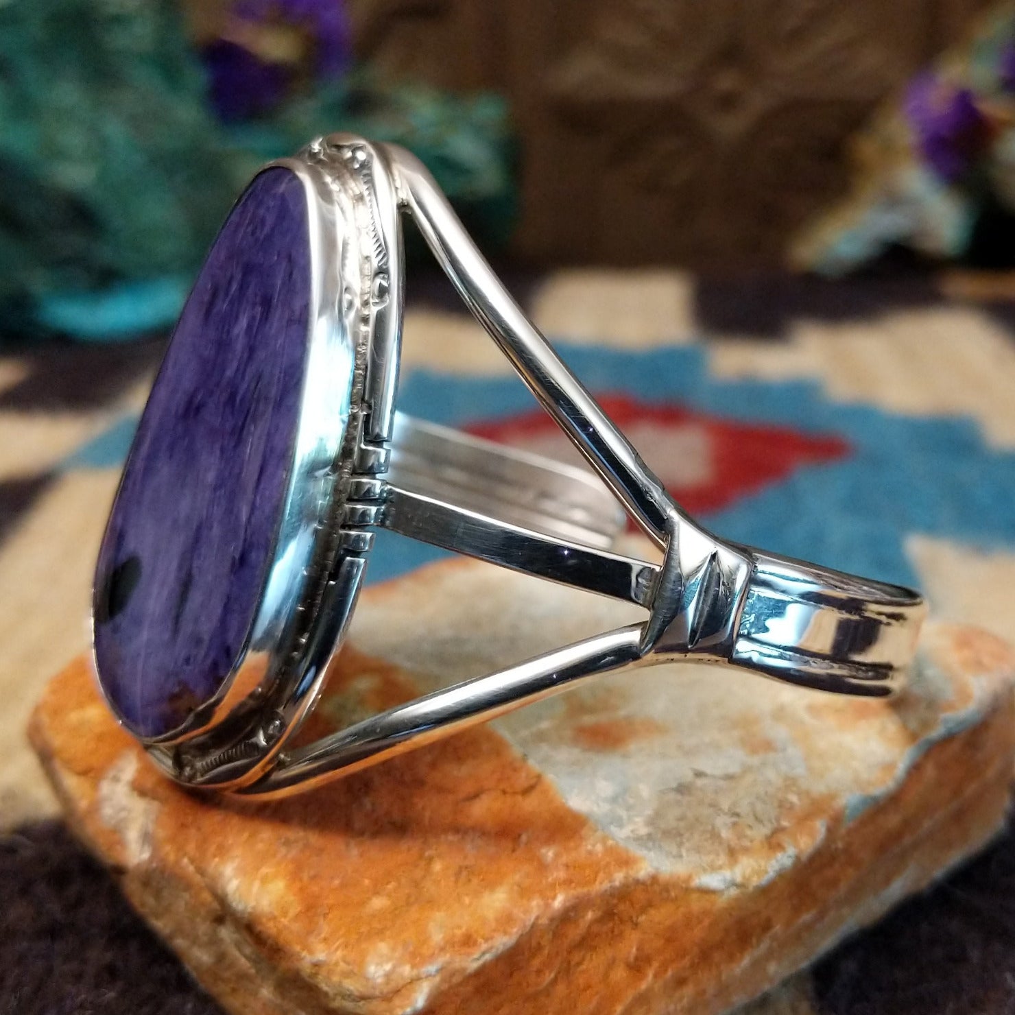 Large charoite cuff by Richard Kee, featuring a bold purple charoite stone with natural swirling patterns and handcrafted Southwestern-inspired metalwork.  Side view.