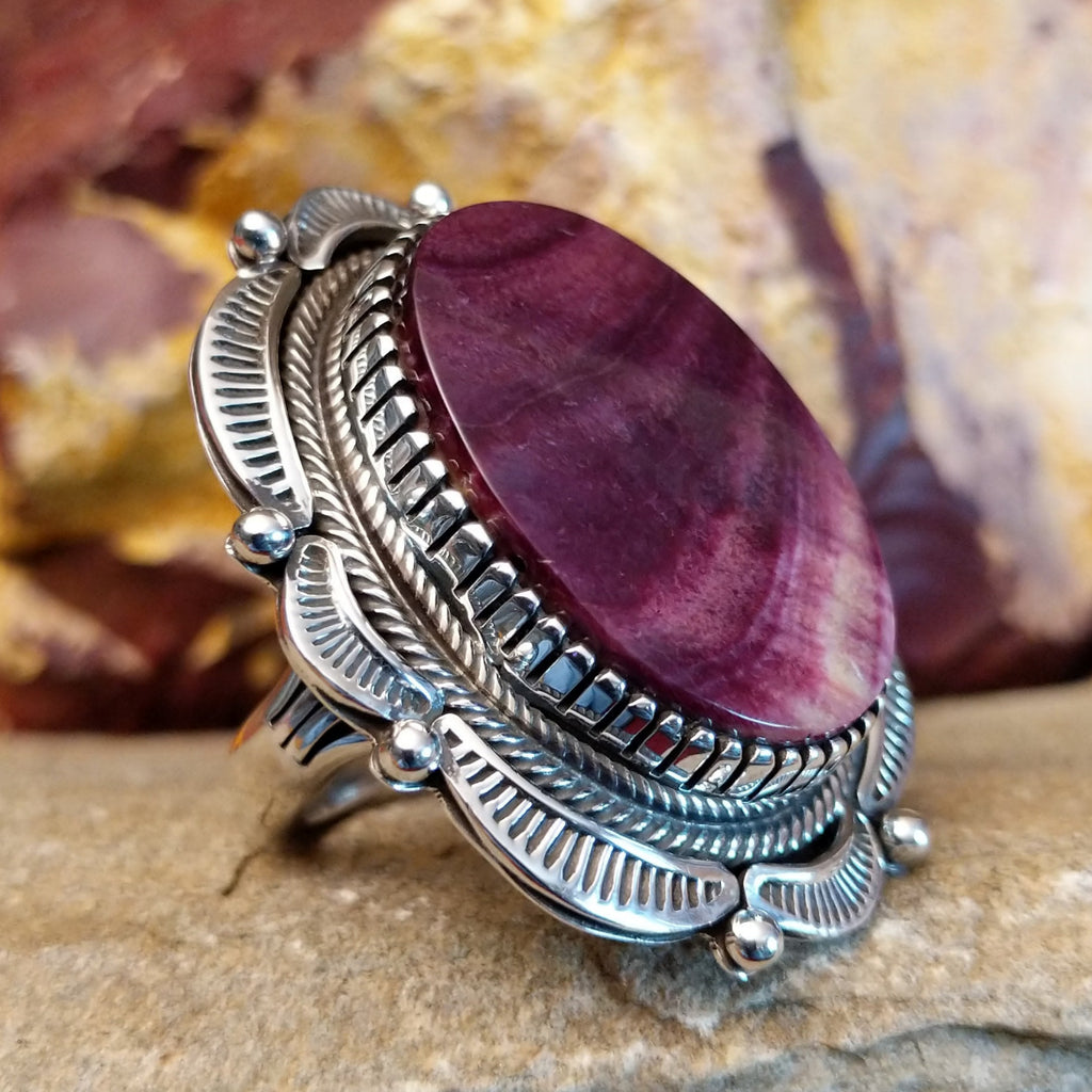 Large, oval purple spiny oyster shell set in a notched bezel with twisted rope accents and a scalloped edge.