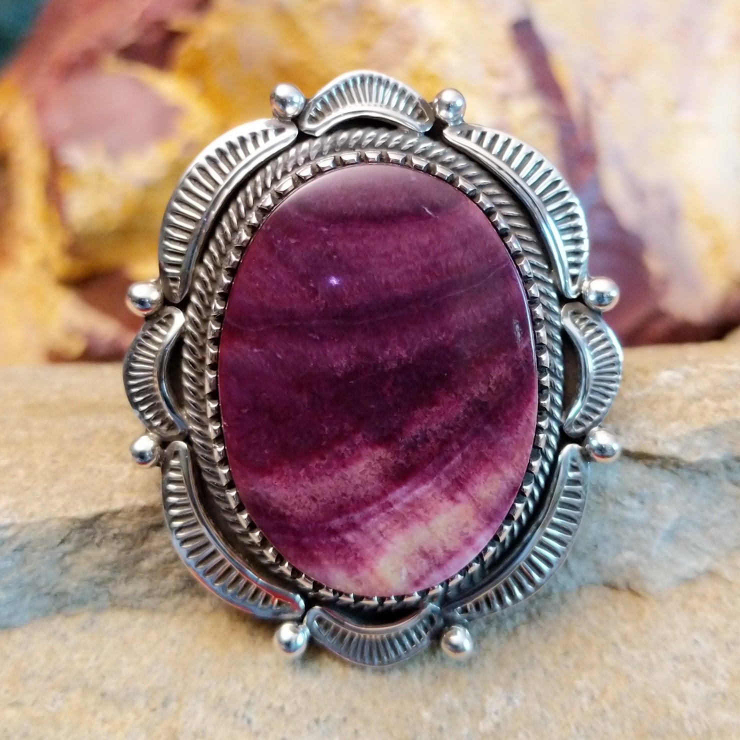 Large, oval purple spiny oyster shell set in a notched bezel with twisted rope accents and a scalloped edge.