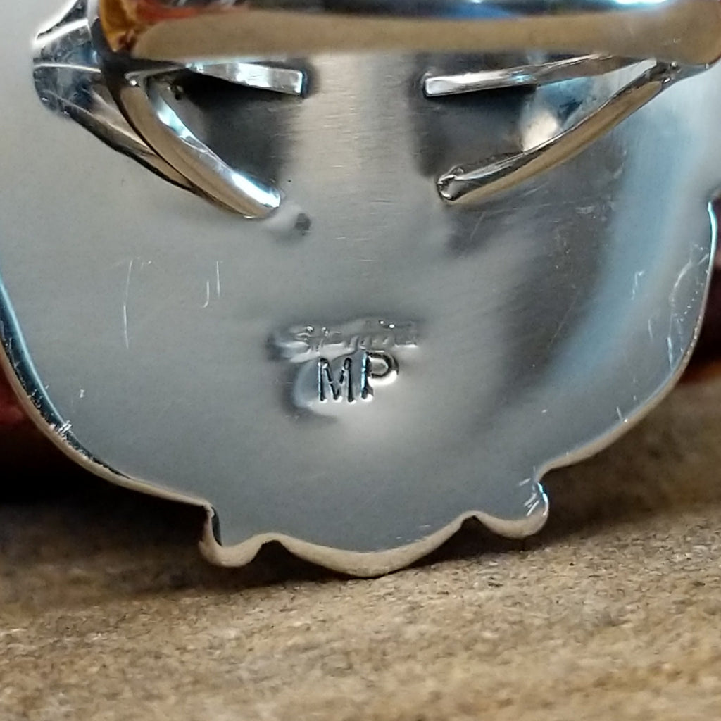The artisan's initials are stamped on the underside of the bezel.