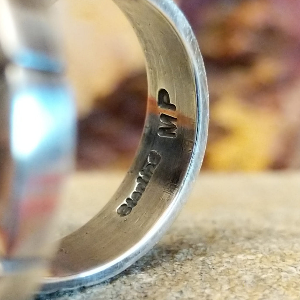 The artisan's signature is found on the underside of the band.