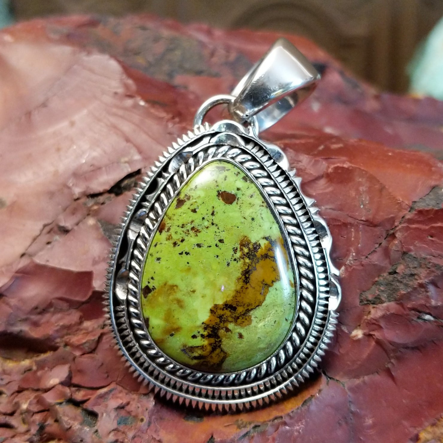 Sterling silver pendant with gaspeite framed by twisted rope and intricately detailed bezel.