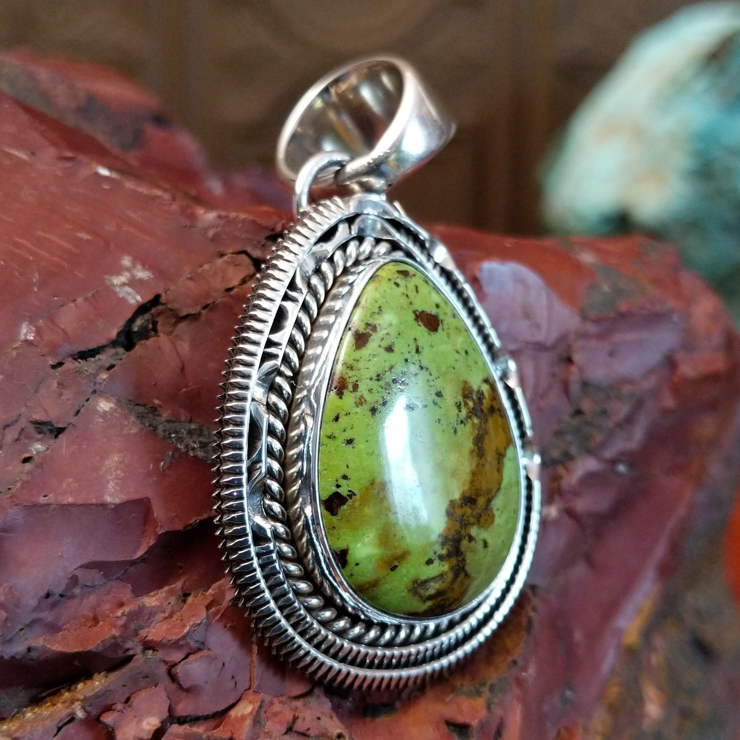 Sterling silver pendant with gaspeite framed by twisted rope and intricately detailed bezel.
