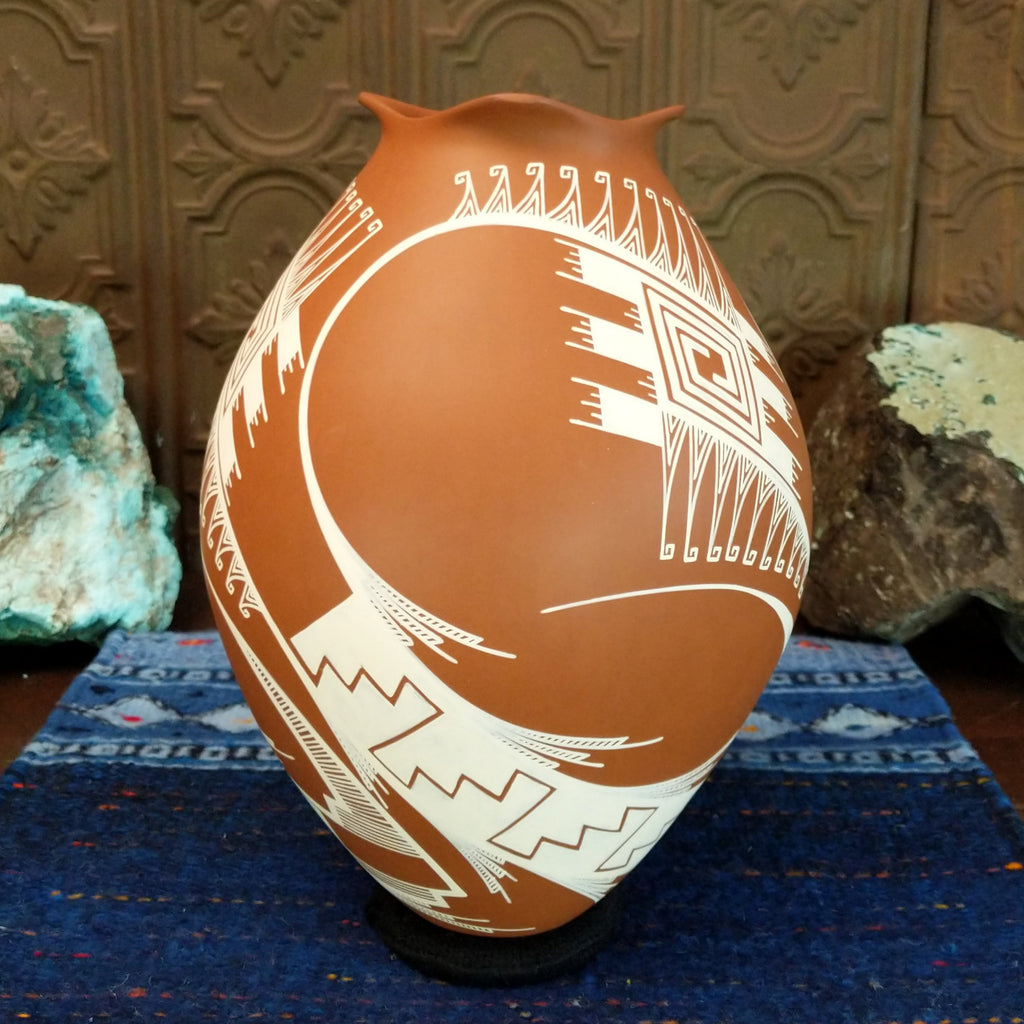 Terracotta clay with intricate white geometric patterns.