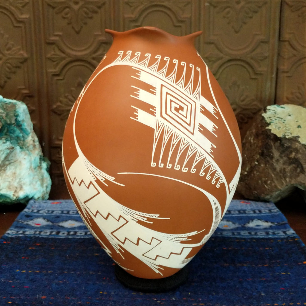 Terracotta clay with intricate white geometric patterns.