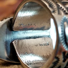 The artist's signature is on the inside of the band.