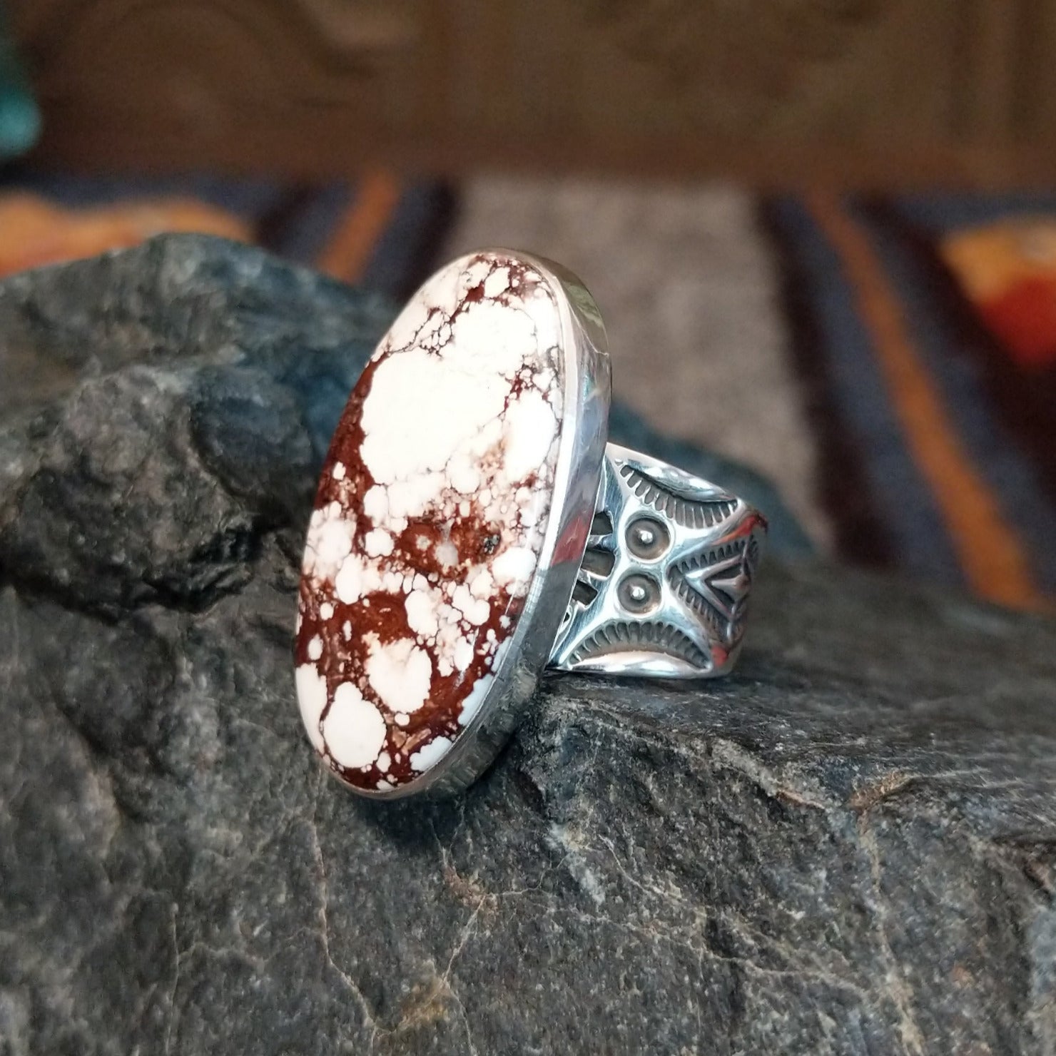 Oval ring set in silver with intricate band detailing.