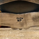 The inside of the cuff features the artist's stamp.