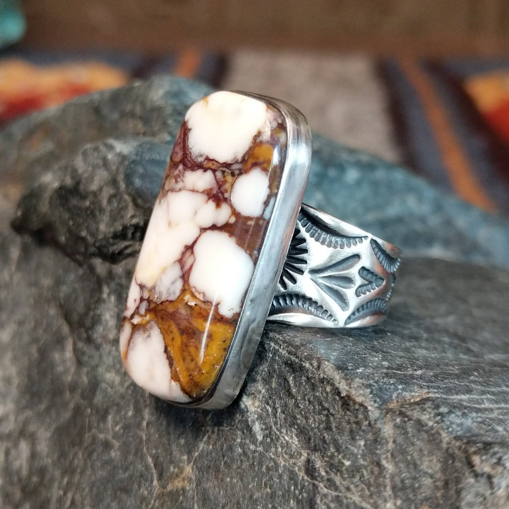 Wild horse stone with brown matrix set in a polished bezel and intricate stamps along the band.